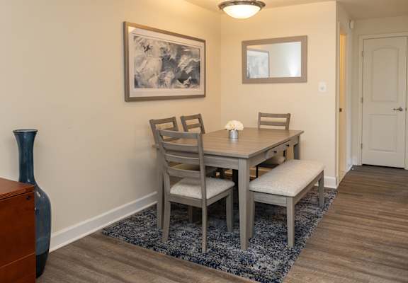 A dining room with a table and chairs.