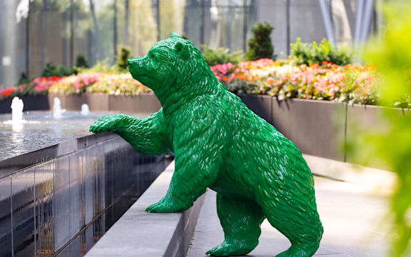 A green bear statue is standing on its hind legs.