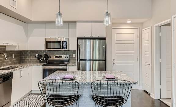 a kitchen with white cabinets and stainless steel appliances