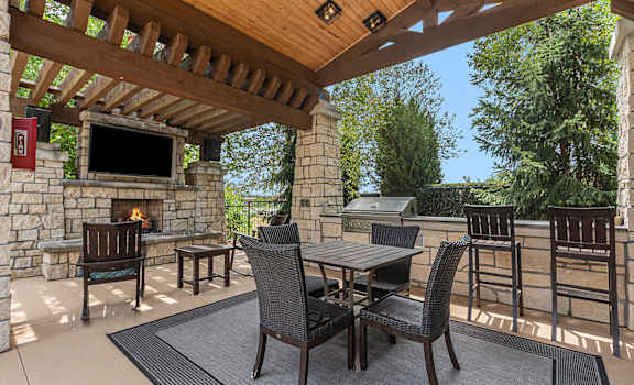a patio with chairs and a fireplace