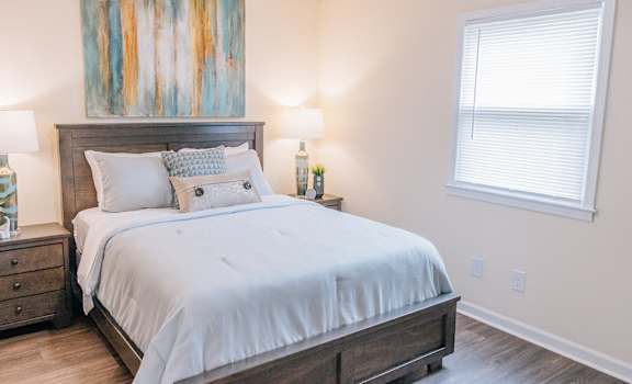 a bedroom with a bed and a painting on the wall