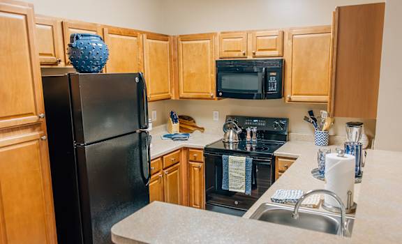 a kitchen with black appliances and wood cabinets