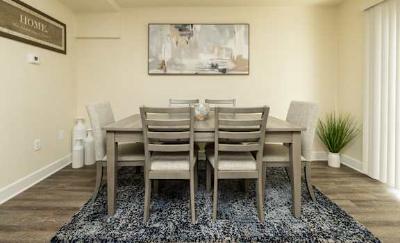 A dining room with a table and chairs.