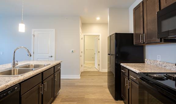 A kitchen with black appliances and wooden cabinets.