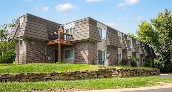 A modern house with a stone wall in front.
