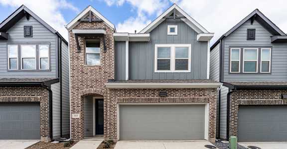 two story house with brick and gray siding and a garage