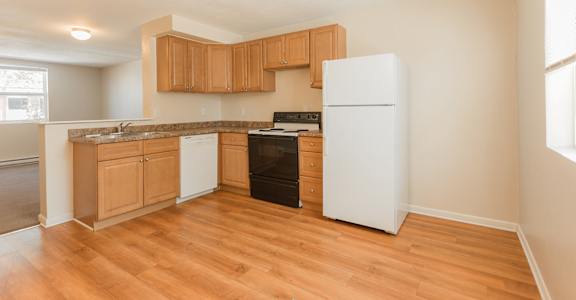 A kitchen with wooden cabinets and a white refrigerator.