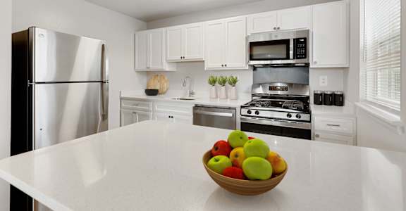 a kitchen with white cabinets and a bowl of fruit on the counter, Kenilworth at Perring Park, Baltimore MD