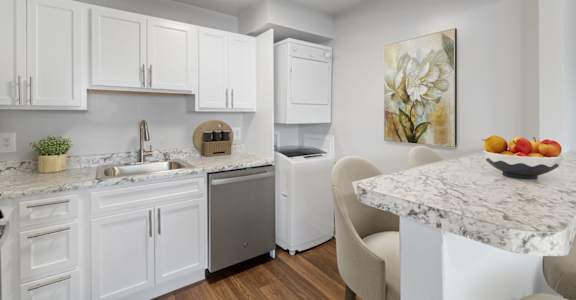 a kitchen with white cabinetry and a countertop with a bowl of fruit on it at Falls Village Apartments, Baltimore MD