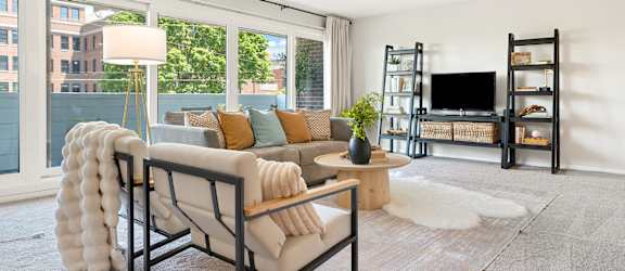 A living room with a white couch and a black chair.