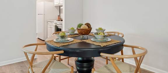 A dining room with a round table and chairs.