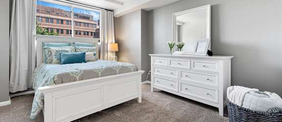 A bedroom with a bed, dresser, and mirror.