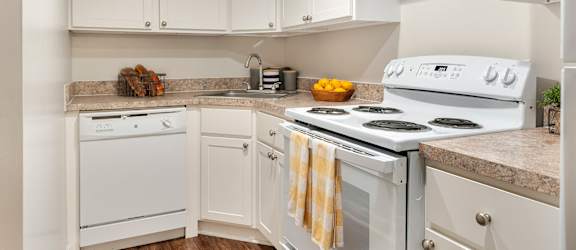 A kitchen with white appliances and cabinets.