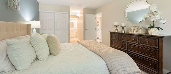 A bedroom with a bed, dresser, and mirror.