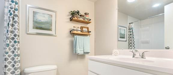 A white toilet sits next to a white sink in a bathroom.
