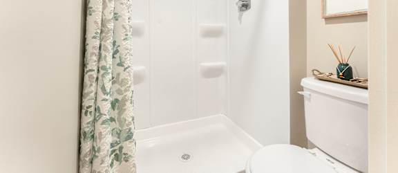 A white bathroom with a shower and toilet.