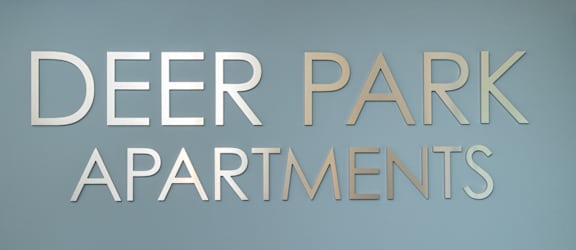 A sign that says Deer Park Apartments.
