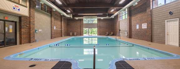 A large indoor pool with a sign at Kimberly Club Apartments, Davenport , Iowa
