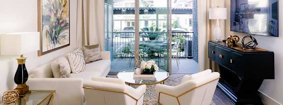 A living room with a white sofa, a coffee table, and a ceiling fan.