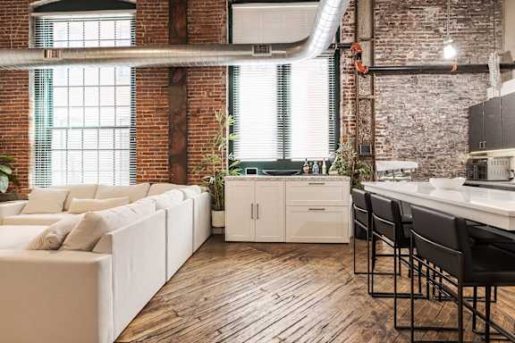 A modern kitchen with white cabinets and a wooden floor.