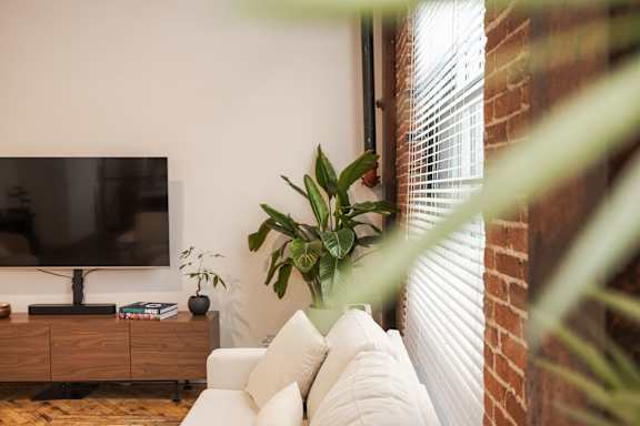 A living room with a white couch and a flat screen TV.