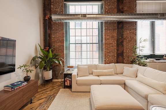A living room with a white couch and a wooden cabinet.