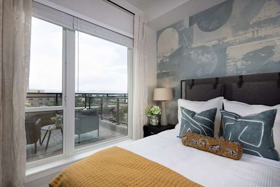 A bedroom with a large bed and a view of the city.