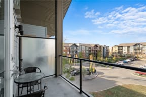 a balcony with a table and chairs and a view of a parking lot