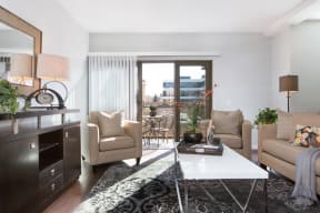 Livingroom with Hardwood-Style Floor, Area Rug, Sofa, Two Armchairs, Coffeetable, Cabinet, Lamps, Decorative Mirror, and Door with Access to Private Balcony at Nineteen800, Cupertino