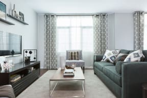 Living Room Area With Large Couch, Hard-Style Flooring, Modern Decor, Floor-To-Ceiling Windows, And Area Rug  at Nineteen800, Cupertino, California
