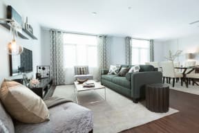 Living Room Area With Large Couch, Hard-Style Flooring, Modern Decor, Floor-To-Ceiling Windows, And Area Rug at Nineteen800, Cupertino, CA, 95014