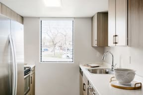Renovated kitchen with light brown cabinetry and stainless steel appliances