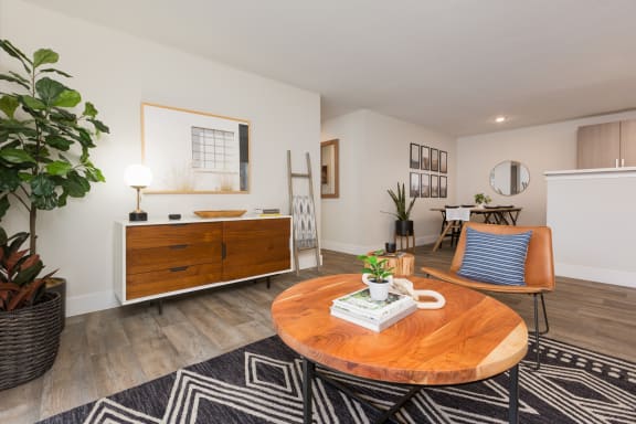 Living room with a coffee table and a dining room table in the background at Brookside 112, Vancouver