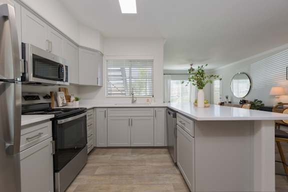 A kitchen with white cabinets and appliances.