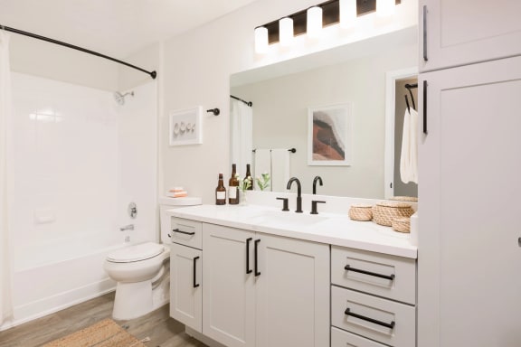 a bathroom with white cabinets and a white toilet