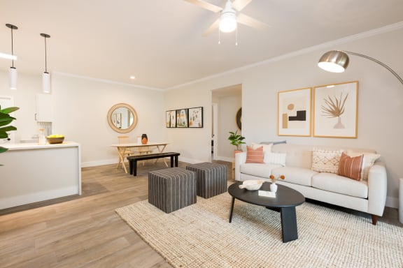 a living room with white walls and a ceiling fan