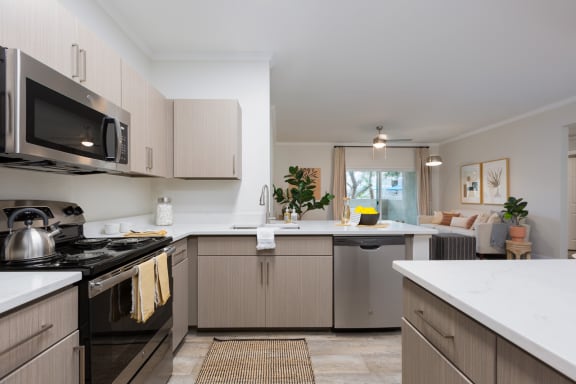 a kitchen with white countertops and stainless steel appliances
