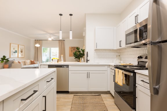 a kitchen with white cabinets and stainless steel appliances