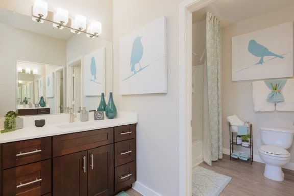 a bathroom with dark wood cabinets and white countertops