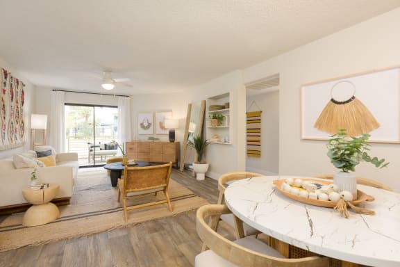 a living room with a white table and chairs and a sliding glass door leading to a patio