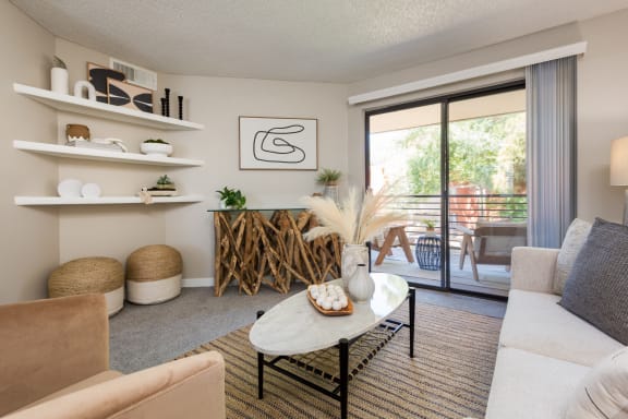 a living room with a sliding glass door that leads to a balcony