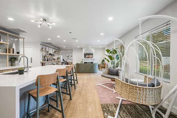 A modern open plan living and dining area with wooden floors and furniture.