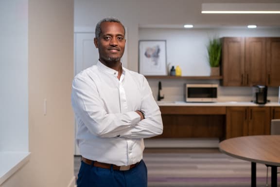 a man standing in an office with his arms crossed