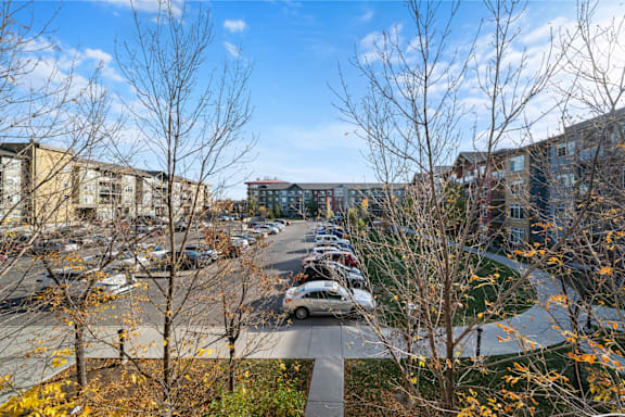 a parking lot with cars parked in front of apartment buildings