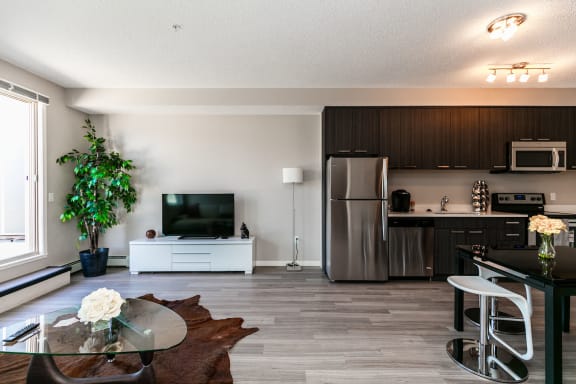 a kitchen and living room with a table and a tv