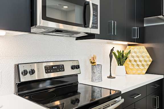 a kitchen with a stove and a microwave at The Hendry, Henderson, 89074