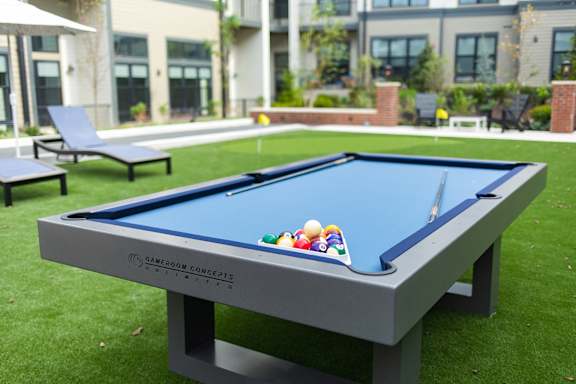 a pool table with balls on top of it in the backyard of a house