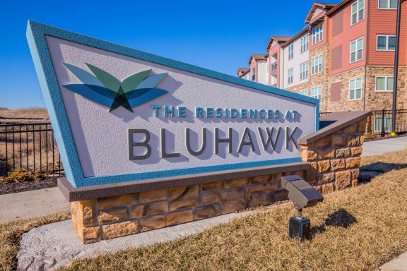 a sign for the residences in front of a building at The Residences at Bluhawk Apartment Homes, Overland Park, Kansas