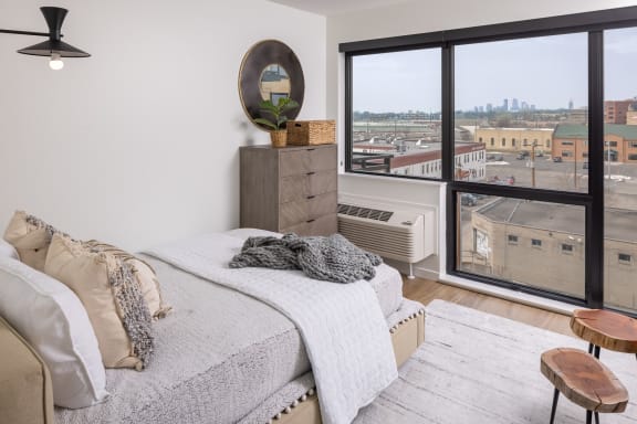a bedroom with a bed and a large window