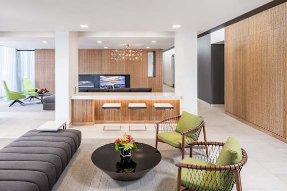 A modern living room with a black coffee table and green chairs.